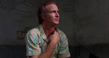 Movie still from “Kiss of the Spider Woman” (1985), directed by Hector Babenco – A man in a hawaiian shirt is looking up; Close Up shot, Low angle