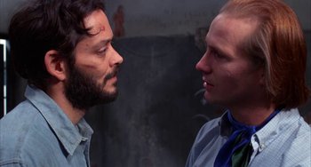 Movie still from “Kiss of the Spider Woman” (1985), directed by Hector Babenco – Two men face each other in a room; Close Up shot, Over the shoulder angle