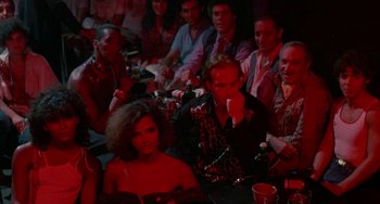 Movie still from “Kiss of the Spider Woman” (1985), directed by Hector Babenco – A group of men and women sitting at a table; Wide shot, High angle