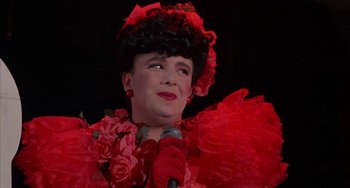 Movie still from “Kiss of the Spider Woman” (1985), directed by Hector Babenco – A woman in a red dress holding a microphone; Close Up shot, Low angle