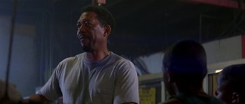 Movie still from “Kiss the Girls” (1997), directed by Gary Fleder – A man standing next to another man in front of a building; Close Up shot, Low angle