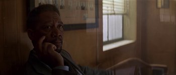 Movie still from “Kiss the Girls” (1997), directed by Gary Fleder – A man sitting in front of a window with his hand to his face; Close Up shot, Over the shoulder angle