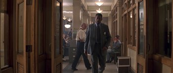 Movie still from “Kiss the Girls” (1997), directed by Gary Fleder – A man in a suit walking down a hall way; Wide shot, Low angle