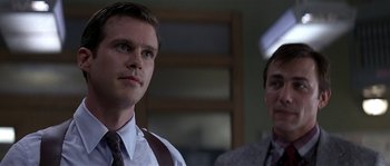 Movie still from “Kiss the Girls” (1997), directed by Gary Fleder – A man in a suit and tie standing next to another man in a suit and tie; Close Up shot, Low angle