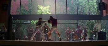 Movie still from “Kiss the Girls” (1997), directed by Gary Fleder – Two men are fighting in front of an audience; Wide shot, Over the shoulder angle
