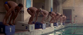 Movie still from “Kiss the Girls” (1997), directed by Gary Fleder – A group of men standing on top of blocks in a swimming pool; Wide shot, Low angle