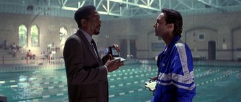 Movie still from “Kiss the Girls” (1997), directed by Gary Fleder – Two men talking in front of an indoor swimming pool; Medium shot, Over the shoulder angle