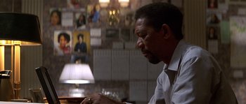 Movie still from “Kiss the Girls” (1997), directed by Gary Fleder – A person sitting at a table; Close Up shot, Over the shoulder angle