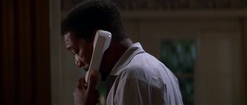 Movie still from “Kiss the Girls” (1997), directed by Gary Fleder – A man holding a phone up to his ear; Close Up shot, Low angle