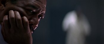 Movie still from “Kiss the Girls” (1997), directed by Gary Fleder – A man's face in a dark room; Close Up shot, Low angle