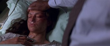 Movie still from “Kiss the Girls” (1997), directed by Gary Fleder – A woman laying in a bed with a knife on her face; Close Up shot, Over the shoulder angle