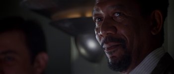 Movie still from “Kiss the Girls” (1997), directed by Gary Fleder – A man's face in a dimly - lit room; Close Up shot, Low angle