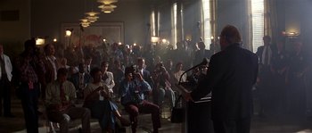 Movie still from “Kiss the Girls” (1997), directed by Gary Fleder – A group of people sitting in a room with microphones and microphones; Wide shot, Over the shoulder angle