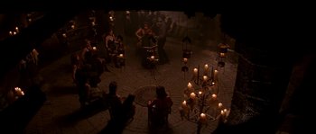 Movie still from “Kiss the Girls” (1997), directed by Gary Fleder – A group of people sitting in a circle with candles; Wide shot, High angle