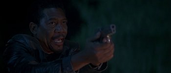 Movie still from “Kiss the Girls” (1997), directed by Gary Fleder – A man holding a gun in his hand; Close Up shot, Low angle
