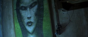 Movie still from “Kiss the Girls” (1997), directed by Gary Fleder – A painting of a woman's face on a wall; Extreme Close Up shot, Low angle