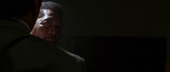 Movie still from “Kiss the Girls” (1997), directed by Gary Fleder – A black man is looking at the camera with a cigarette in his mouth; Close Up shot, Over the shoulder angle