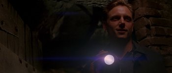 Movie still from “Kiss the Girls” (1997), directed by Gary Fleder – A man is holding a flashlight in a cave; Close Up shot, Low angle
