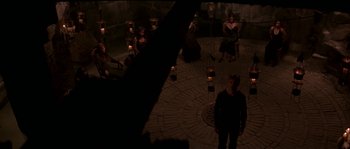 Movie still from “Kiss the Girls” (1997), directed by Gary Fleder – A group of people sitting in a circle with candles; Wide shot, Overhead angle
