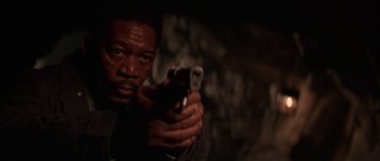 Movie still from “Kiss the Girls” (1997), directed by Gary Fleder – A man holding a cell phone while looking at the camera; Close Up shot, Low angle