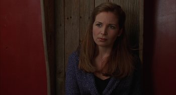 Movie still from “Kissing Jessica Stein” (2001), directed by Charles Herman-Wurmfeld – A woman with long brown hair sitting in front of a wooden wall; Close Up shot, Over the shoulder angle