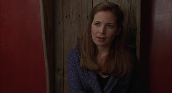 Movie still from “Kissing Jessica Stein” (2001), directed by Charles Herman-Wurmfeld – A woman sitting in front of a wooden wall; Close Up shot, Over the shoulder angle