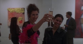 Movie still from “Kissing Jessica Stein” (2001), directed by Charles Herman-Wurmfeld – A woman holding up a glass of champagne to the camera; Medium shot, Low angle