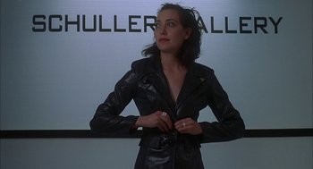 Movie still from “Kissing Jessica Stein” (2001), directed by Charles Herman-Wurmfeld – A woman in a black leather jacket standing in front of a white wall; Medium shot, Low angle