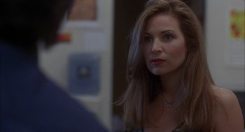 Movie still from “Kissing Jessica Stein” (2001), directed by Charles Herman-Wurmfeld – A woman looking into a mirror while wearing a necklace; Close Up shot, Over the shoulder angle