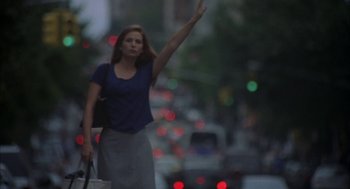 Movie still from “Kissing Jessica Stein” (2001), directed by Charles Herman-Wurmfeld – A woman walking down the street waving at the camera; Medium shot, Low angle