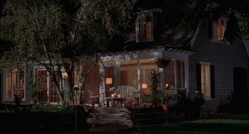 Movie still from “Kissing Jessica Stein” (2001), directed by Charles Herman-Wurmfeld – A porch with a bench and a table in front of a house at night; Wide shot, High angle