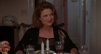 Movie still from “Kissing Jessica Stein” (2001), directed by Charles Herman-Wurmfeld – A woman sitting at a dinner table with a glass of wine; Close Up shot, Over the shoulder angle
