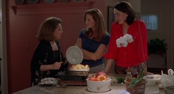 Movie still from “Kissing Jessica Stein” (2001), directed by Charles Herman-Wurmfeld – A group of women standing around a table with food; Medium shot, Over the shoulder angle
