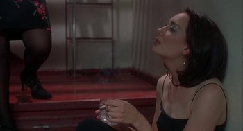 Movie still from “Kissing Jessica Stein” (2001), directed by Charles Herman-Wurmfeld – A woman sitting on the ground holding a glass of wine; Close Up shot, High angle