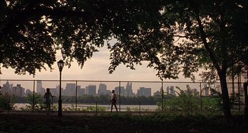 Movie still from “Kissing Jessica Stein” (2001), directed by Charles Herman-Wurmfeld – A person is walking on a path near a fence; Extreme Wide shot, Low angle