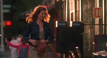 Movie still from “Kissing Jessica Stein” (2001), directed by Charles Herman-Wurmfeld – A woman walking down a street holding a purse; Medium shot, Over the shoulder angle