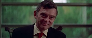 Movie still from “Klute” (1971), directed by Alan J. Pakula – A person wearing a suit and tie; Close Up shot, Low angle