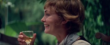 Movie still from “Klute” (1971), directed by Alan J. Pakula – A person smiling and holding something; Close Up shot, Over the shoulder angle