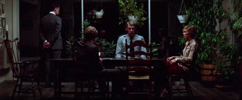 Movie still from “Klute” (1971), directed by Alan J. Pakula – A group of people sitting around a table; Wide shot, Over the shoulder angle