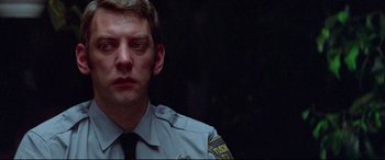 Movie still from “Klute” (1971), directed by Alan J. Pakula – A man in a police uniform looking to his left; Close Up shot, Low angle