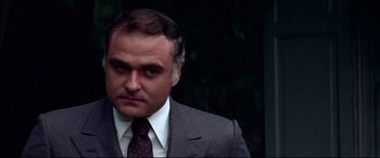 Movie still from “Klute” (1971), directed by Alan J. Pakula – A person wearing a suit and tie; Close Up shot, Low angle