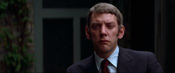 Movie still from “Klute” (1971), directed by Alan J. Pakula – A person wearing a suit and tie; Close Up shot, Low angle