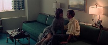 Movie still from “Klute” (1971), directed by Alan J. Pakula – A man and a woman sitting on a green couch; Medium shot, High angle