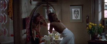 Movie still from “Klute” (1971), directed by Alan J. Pakula – A woman is looking in the mirror in front of the mirror; Medium shot, Over the shoulder angle