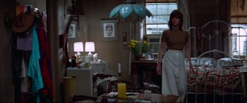 Movie still from “Klute” (1971), directed by Alan J. Pakula – A woman standing in front of a table in a living room; Wide shot, Low angle