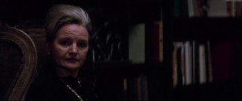 Movie still from “Klute” (1971), directed by Alan J. Pakula – A woman in a black shirt and a gold chain; Close Up shot, Over the shoulder angle