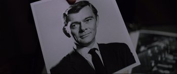 Movie still from “Klute” (1971), directed by Alan J. Pakula – A black and white photo of a man in a suit; Close Up shot, High angle