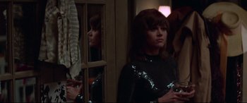 Movie still from “Klute” (1971), directed by Alan J. Pakula – A woman standing in front of a mirror in front of a window; Medium shot, Over the shoulder angle