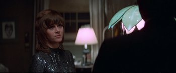 Movie still from “Klute” (1971), directed by Alan J. Pakula – A woman in a sequined top is standing next to a man; Close Up shot, Over the shoulder angle