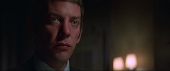 Movie still from “Klute” (1971), directed by Alan J. Pakula – A man's face in a dark room; Close Up shot, Low angle